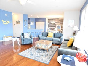 Relax in this stylish living room with a sofa, coffee table, and dining area, offering a view of the city.