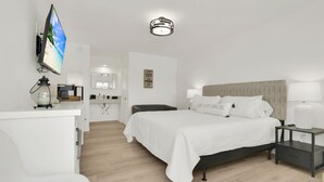A modern hotel room with a large bed, bedside tables, a flat-screen TV, and a bathroom visible in the background. - Boutique Hotel King room w/ POOL, LOCATION! Walk to BEACH/Restaurants/Nightlife (Deerfield Beach)