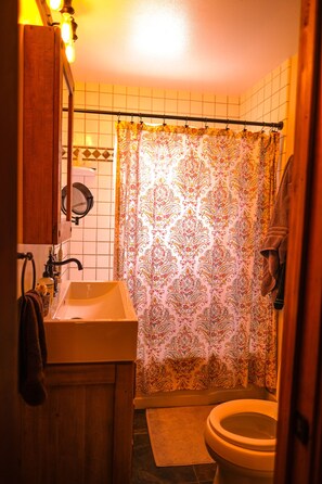 Een douche, handdoeken, zeep, toiletpapier