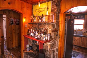 Enjoy a warm and inviting atmosphere in this rustic cabin-style bar area, featuring a wooden countertop and a unique brass trumpet decoration.