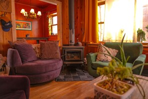 Cozy space with a central wood-burning stove, comfortable seating, and a touch of greenery.