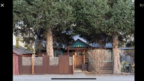 A rustic cabin with a wooden exterior, a green door, and a bicycle parked outside. - Cozy Wilson Cabin (Wilson)