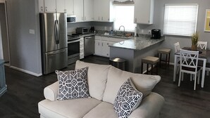 Een moderne keuken met roestvrijstalen apparatuur, witte kasten en een centraal eiland.