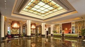 A spacious lobby with a polished marble floor, a central seating area, and a reception desk. - Beijing Chunhuiyuan Hot Spring Resort Hotel (Beijing)