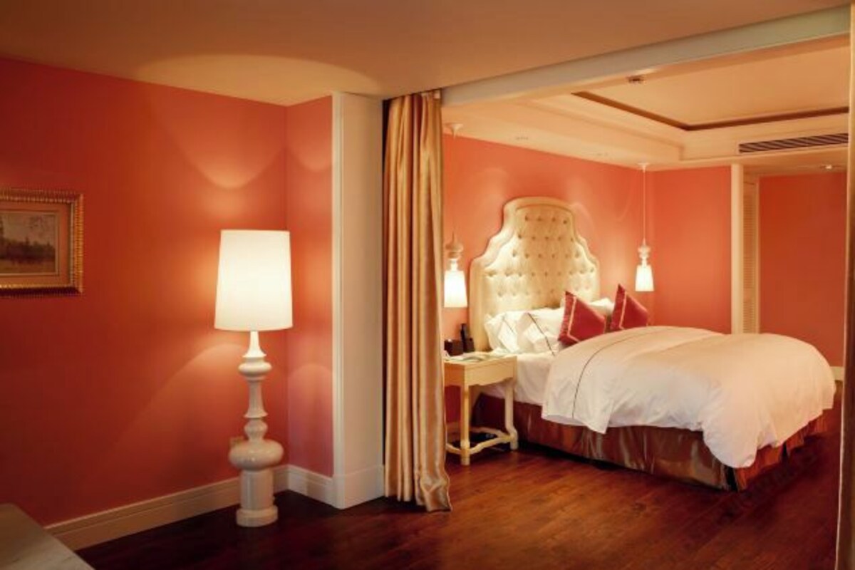 Habitación de hotel con una cama grande, una mesita de noche, una lámpara y un cuadro en la pared.
