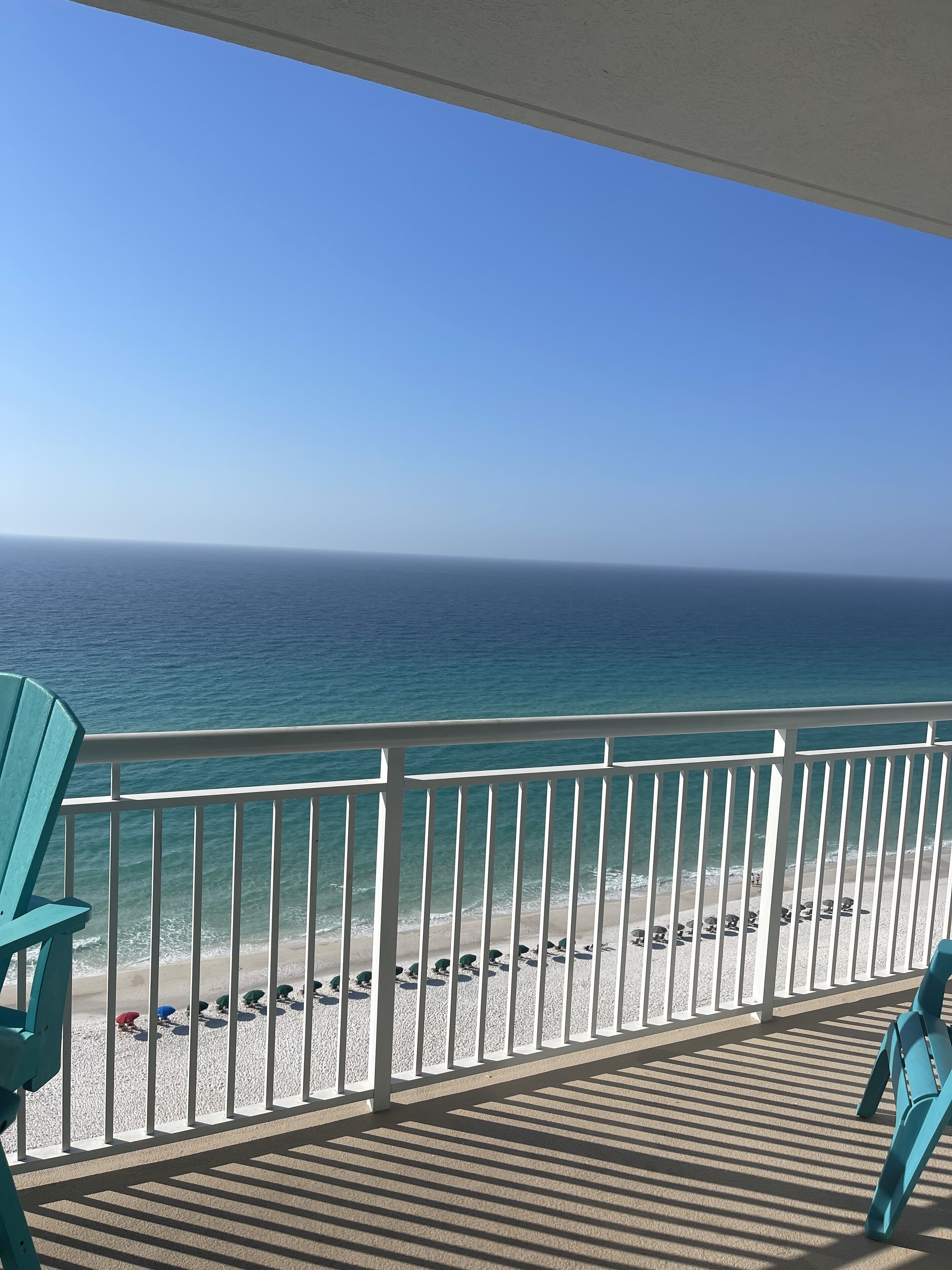 Un balcon avec vue sur la plage et l’océan.