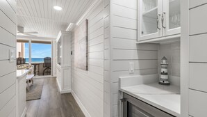 Une cuisine moderne avec des meubles blancs, une cuisinière encastrée et une vue sur l’extérieur.