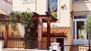 A two-story house with a tiled roof, a wooden pergola, and a gate. - Viktorov Comfortable 2-bed Apartment (Medulin)