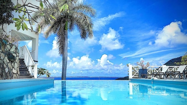 A clear blue pool with a palm tree, a staircase, and lounge chairs. - Villa Casa Sand, luxury, 5 min walk from Anse Marcel beach (Anse Marcel)