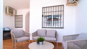 A patio with two wicker chairs, a small round table, and a potted plant. - Mediterraneo 20E by Casasol (Nerja)