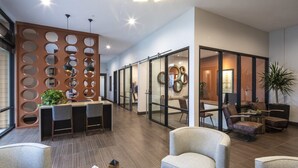 A modern lobby with a reception desk, seating area, and glass partitions. - Luxury Condos Menlo Park (Menlo Park)