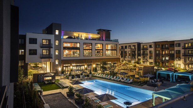 A modern hotel with a rooftop pool, multiple balconies, and outdoor seating areas. - Luxury Condos Menlo Park (Menlo Park)