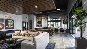 A spacious lobby with a modern design, featuring a sofa, a pool table, and a large potted plant. - Luxury Condos Menlo Park (Menlo Park)