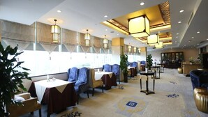 A hotel lobby with seating areas, tables, and a reception desk. - Mianzhou Hotel (Mianyang)