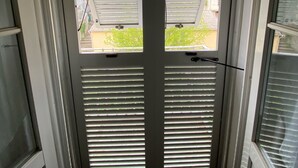 A door with horizontal blinds, a visible lock, and a handle. - Charming T1 full center Corte 13 cours paoli free wifi quiet bright (Corte)