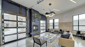 Eine geräumige Lobby mit großen Glastüren, einem Kamin, bequemen Sitzgelegenheiten und großen Fenstern mit Blick.