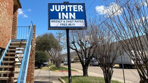 A sign for Jupiter Inn advertising weekly and daily rates and free Wi-Fi. - Jupiter Inn (Garland)