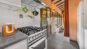 Cozinha com fogão a gás, forno e máquina de café.