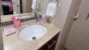 A bathroom with a sink, mirror, and towel rack. - Santiago Moneda Suites 1802 (Santiago)