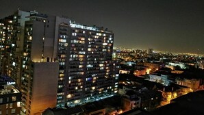 A high-rise building with multiple illuminated windows, likely a hotel or apartment complex, with a view of the cityscape at night. - Santiago Moneda Suites 1802 (Santiago)