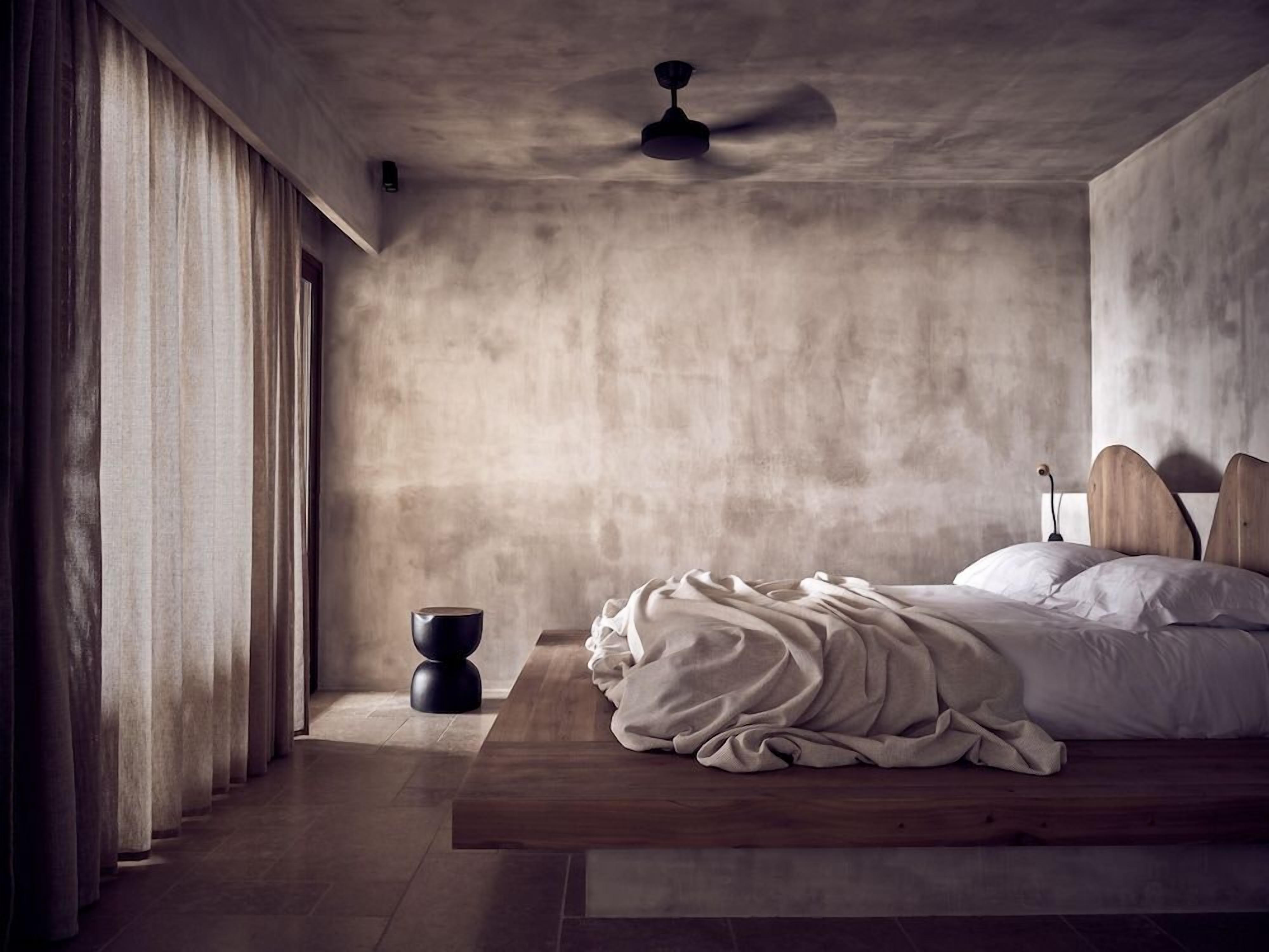 Une chambre à coucher avec un lit, un ventilateur de plafond et une fenêtre avec des rideaux.