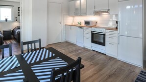 A modern kitchen with white cabinets, a built-in oven, and a microwave. - Beautiful home in Löttorp with WiFi (Löttorp)