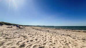 A sandy beach with footprints, a clear sky, and a distant view of the sea. - 3 bedroom stunning home in Hornbæk (Hornbæk)