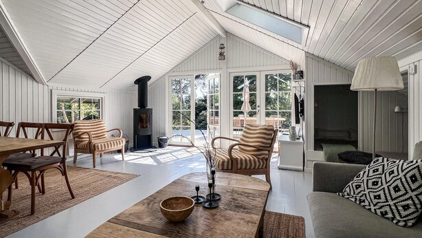 A spacious room with a high ceiling, a fireplace, and large windows. - 3 bedroom stunning home in Hornbæk (Hornbæk)