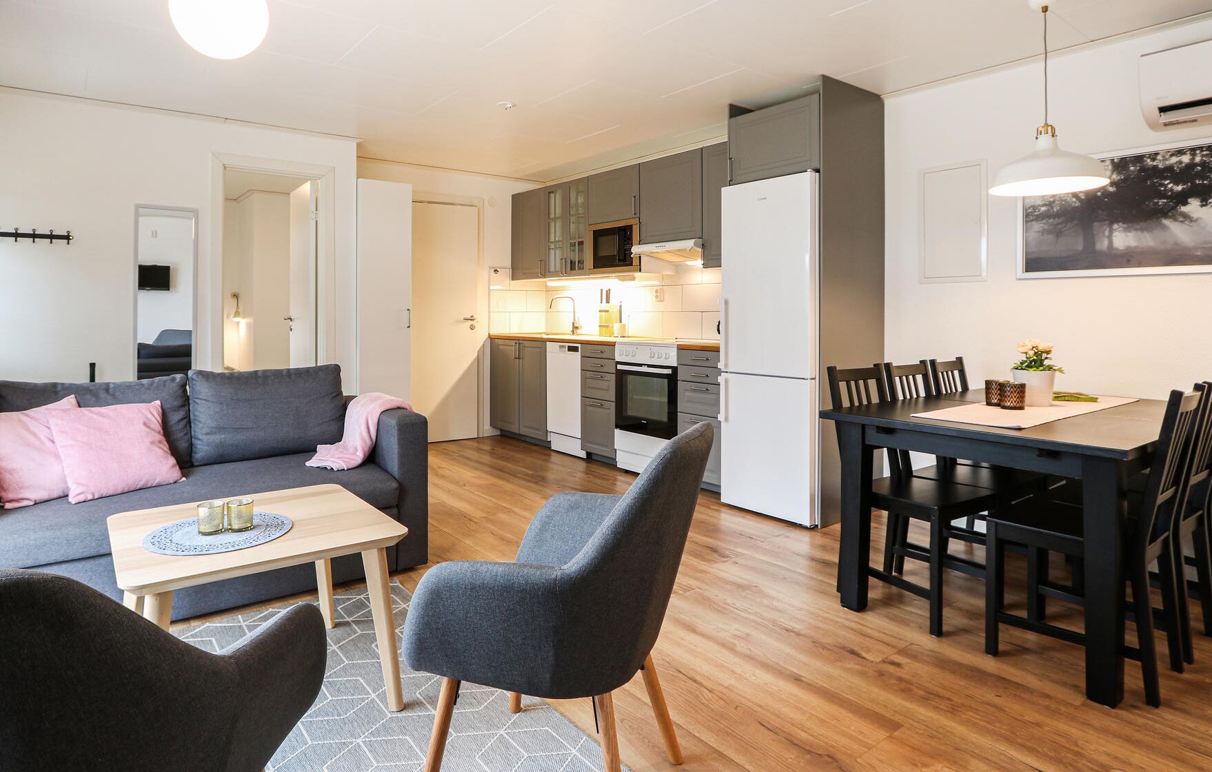 A modern apartment with a living room, dining area, and kitchen.