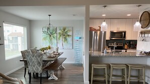 A modern kitchen with stainless steel appliances, a granite countertop, and pendant lighting.