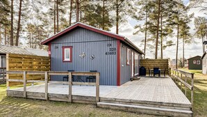 A cabin with a deck, a small table, and chairs. - 3 bedroom cozy home in Löttorp (Löttorp)