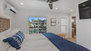 A bedroom with a bed, a ceiling fan, a window, and a view of a building outside. - Luxury 5-Bed, 5-Bath Townhome - 3 King Suites + Bunks - Heated Pool & Hot Tub (St. George)