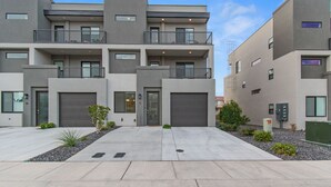 A modern multi-story residential building with balconies, a garage, and a landscaped driveway. - Luxury 5-Bed, 5-Bath Townhome - 3 King Suites + Bunks - Heated Pool & Hot Tub (St. George)