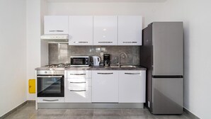 A modern kitchen with white cabinets, a stainless steel refrigerator, a built-in oven, a microwave, and a coffee maker. - 2 bedroom awesome apartment in Rovanjska (Rovanjska)