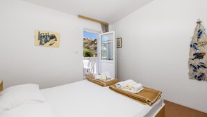 A bedroom with a bed, a window, a door, and a wall with a decorative item. - 2 bedroom lovely apartment in Pag (Pag)