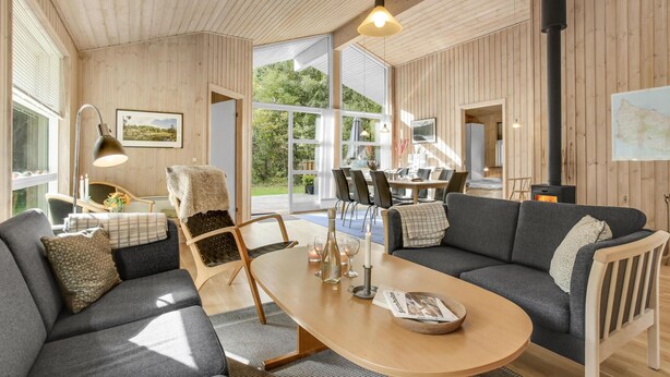 Een gezellige woonkamer met een bank, een eettafel en een open haard.