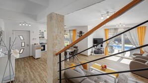 Ein modernes Wohnzimmer mit Sofa, Essbereich und Küche.