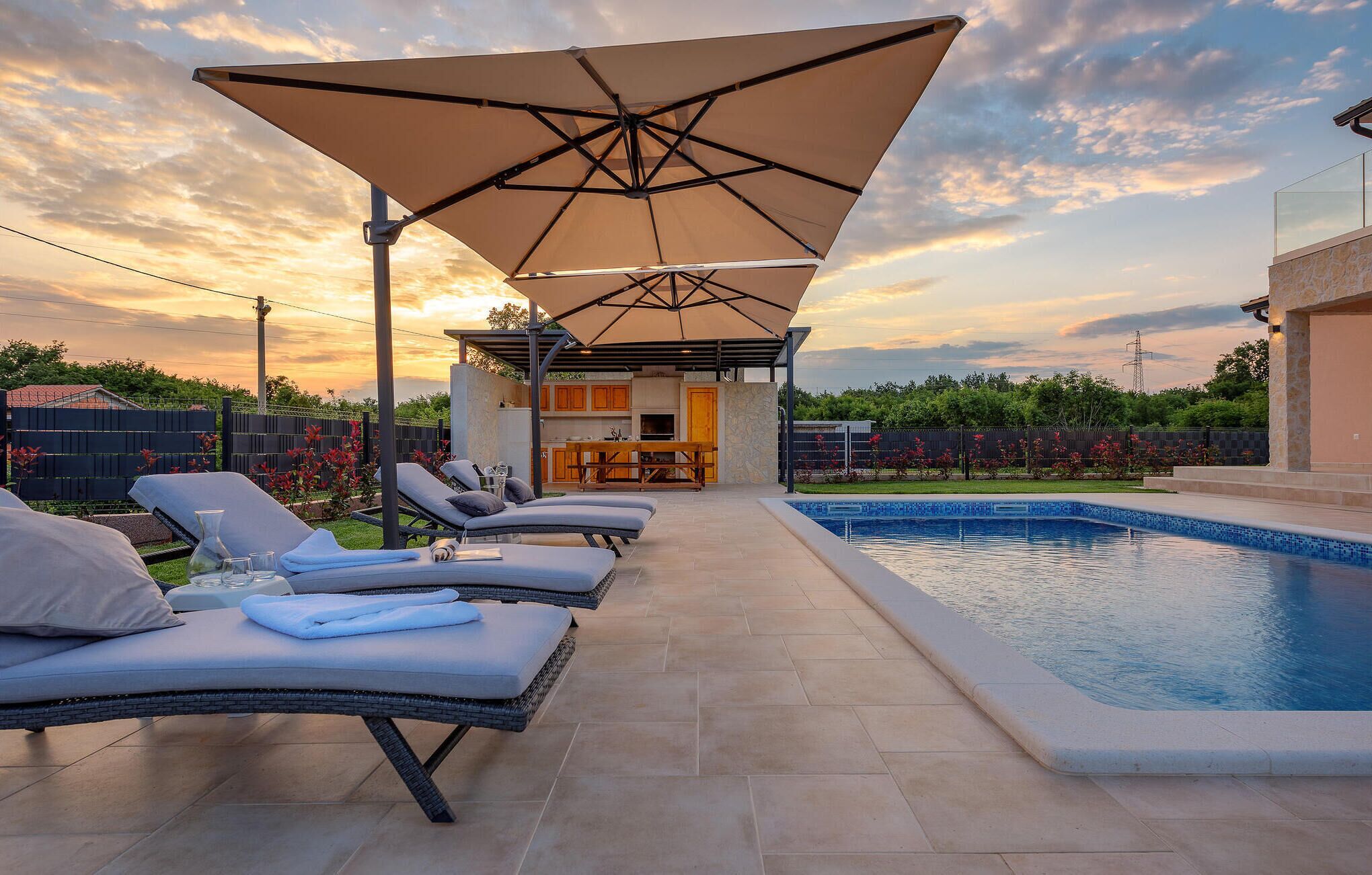 A poolside area with lounge chairs and a covered seating area.