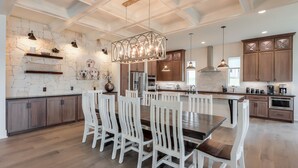 A spacious kitchen with a central island, wooden cabinets, and a stone accent wall.