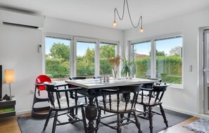 Ein Essbereich mit einem großen Tisch, vier Stühlen und einer Chandelier.