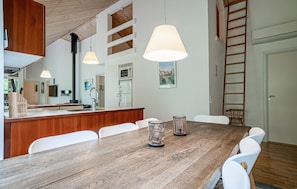 A modern kitchen with a wooden countertop, white chairs, and pendant lights. - Nice home in Hasle with WiFi (Hasle)