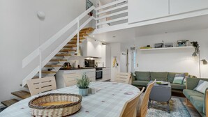 Moderni loft-tyylinen asunto, jossa on keittiö, ruokailutila ja oleskelutila.