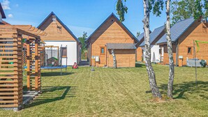 En rad med trähus med en lekplats och en gräsyta framför.