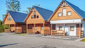 En rad med trähus med sadeltak, numrerade i följd, och en asfalterad gångväg framför.