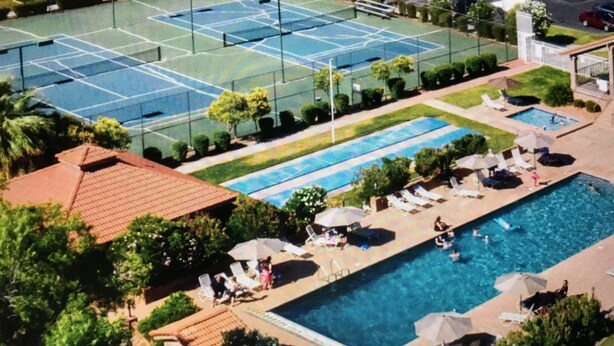 A tennis court with a pool and lounge area. - Greater Zion Villa at Sports Village (St. George)
