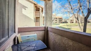 A room with a window overlooking a courtyard. There is a small table and a chair near the window. - Greater Zion Villa at Sports Village (St. George)