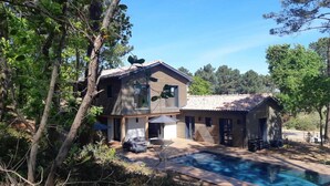 A two-story house with a swimming pool, surrounded by trees and greenery. - Pleasant Villa Domaine du Golf Heated swimming pool (Biscarrosse)