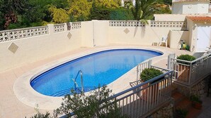 Piscina con recinzione bianca e una scala che conduce a una zona coperta.