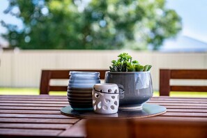 A wooden table with a potted plant, a glass jar, and a ceramic cup. - Campanile House by Your Innkeeper Mudgee (Mudgee)