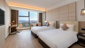 A hotel room with two beds, a desk, a chair, and a large window offering a city view. - Kew Green Hotel Hongqiao Shanghai (Shanghai)